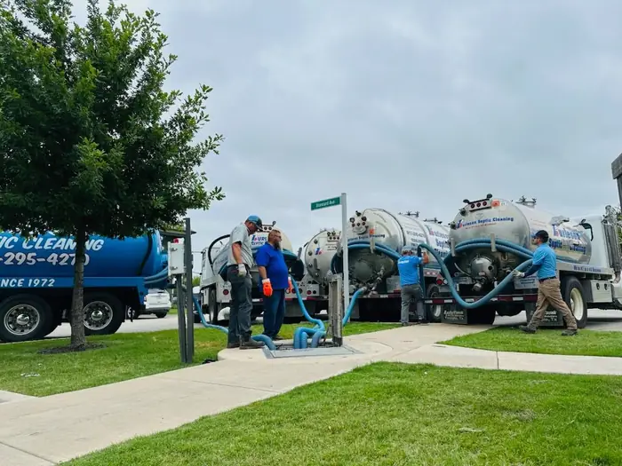 Burleson Septic crew running hoses from the vacuum trucks on site