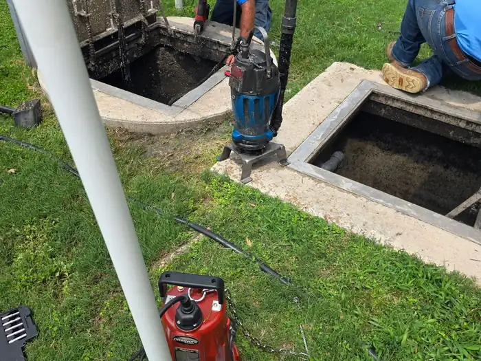 A Burleson Septic technician working inside a commercial lift station